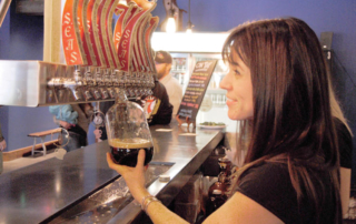 Bartender pouring a dark beer.