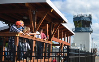 People standing on an observations deck at the harbor.